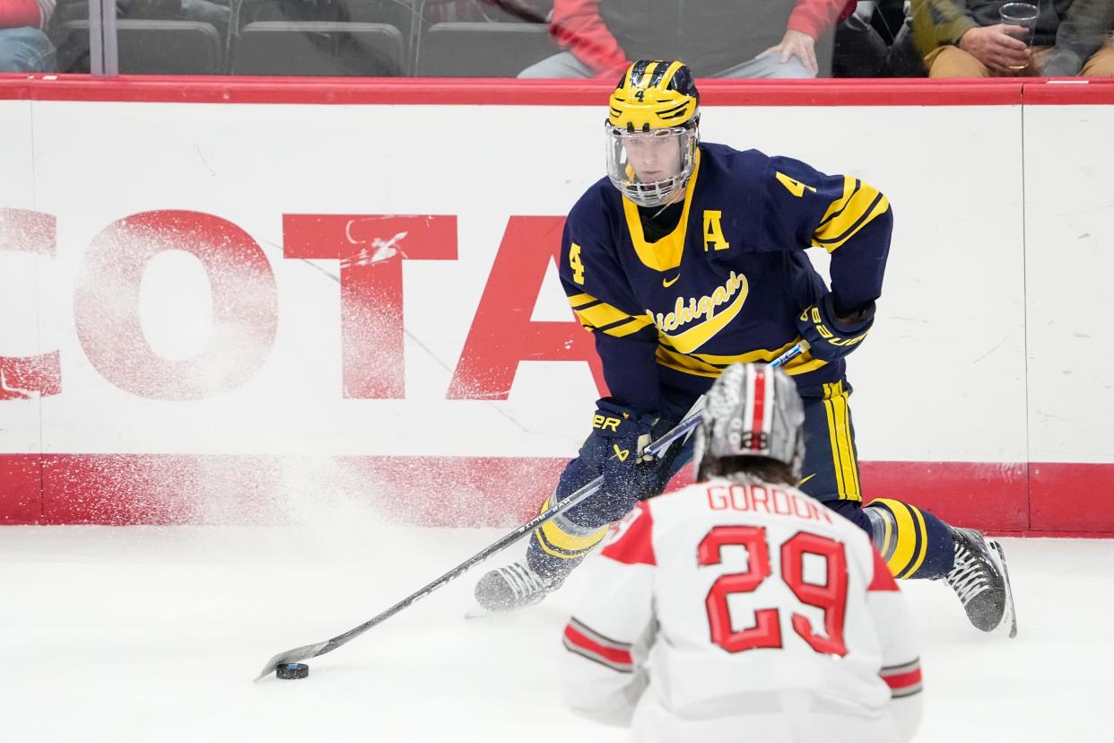 Feb 2, 2024; Columbus, Ohio, USA; Michigan Wolverines forward Gavin Brindley (4) moves the puck around Ohio State Buckeyes forward Ryan Gordon (29) during the NCAA men’s hockey game at Value City Arena.