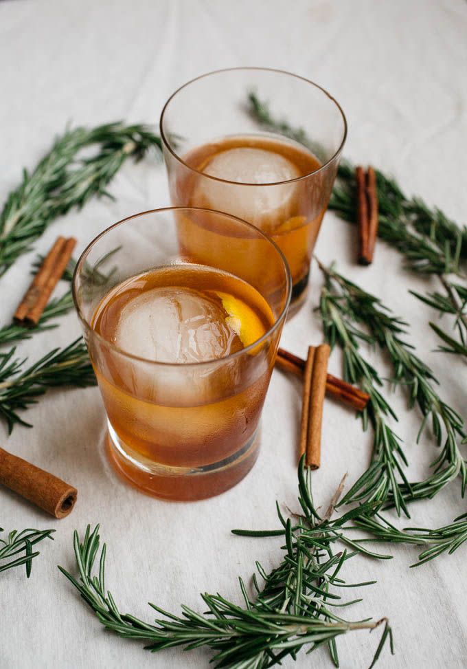 <p>There's nothing like tapping holiday favorites for your menu—and then using them as an added decorative moment. Set up a dark wood bar stocked with amber-toned spirits and encourage guests to pop in throughout the night for a craft cocktail of their choice. We suggest serving wintery riffs on classic cocktails, like the <a href="https://saltedplains.com/cinnamon-rosemary-old-fashioned/" rel="nofollow noopener" target="_blank" data-ylk="slk:cinnamon rosemary old fashioned;elm:context_link;itc:0;sec:content-canvas" class="link ">cinnamon rosemary old fashioned</a> shown here, for a post dinner nightcap, with dessert, or at the after party.</p>