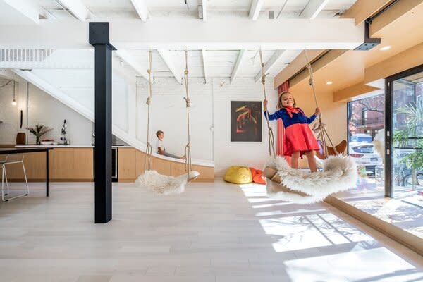 A couple with kids imbued a duplex with the spirit of adventure by including a slide, a climbing wall, a cargo net, and swings.