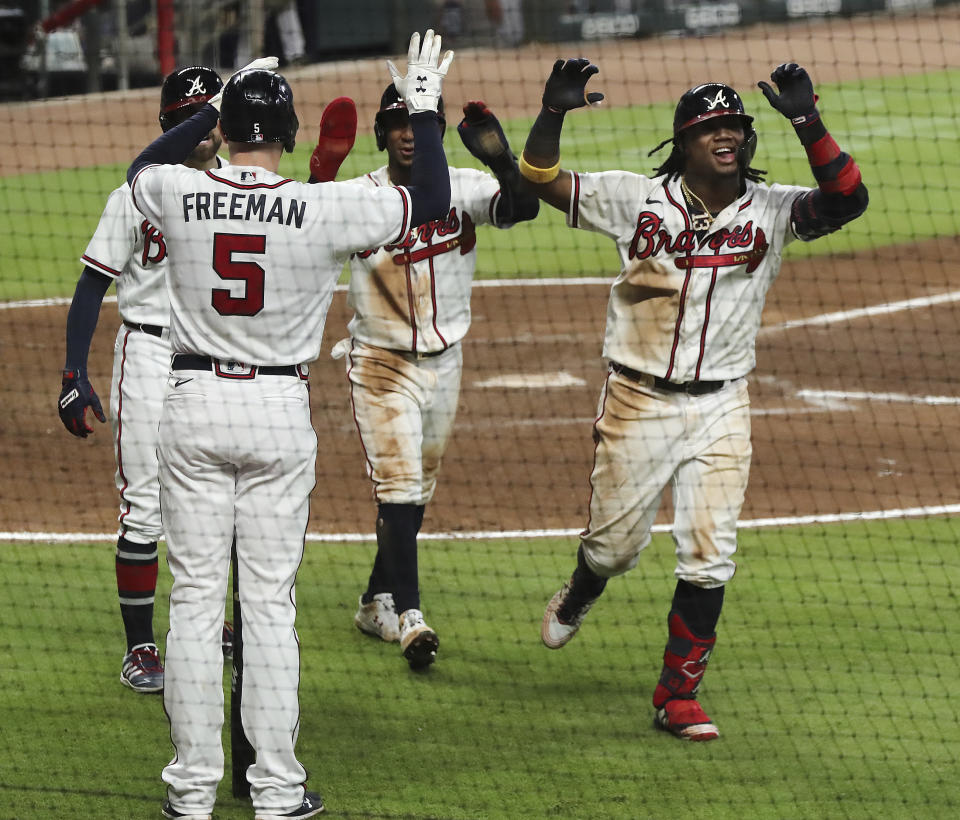 Atlanta Braves Ronald Acuna, right, is greeted at home by Freddie Freeman (5) after he hits a three-run homer for during the fifth inning in a baseball game against the Miami Marlins, Wednesday, Sept. 9, 2020 in Atlanta. (Curtis Compton/Atlanta Journal-Constitution via AP)