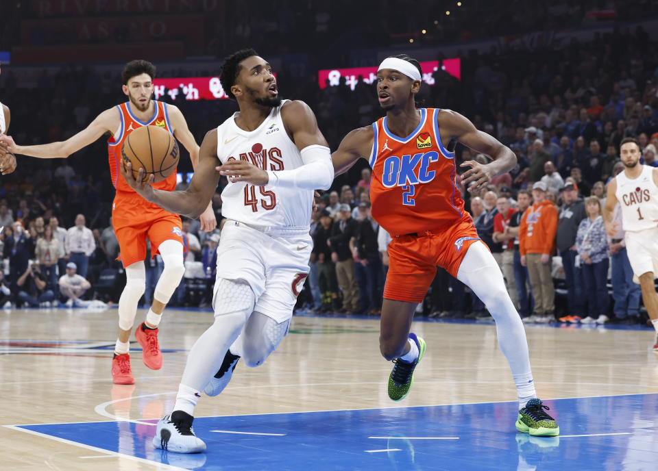 Nov 8, 2023; Oklahoma City, Oklahoma, USA; Cleveland Cavaliers guard Donovan Mitchell (45) drives to the basket against Oklahoma City Thunder guard Shai Gilgeous-Alexander (2) during the first quarter at Paycom Center. Mandatory Credit: Alonzo Adams-USA TODAY Sports