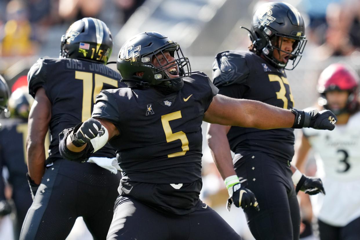 UCF Knights defensive tackle Ricky Barber (5) reacts after a tackle for loss of Cincinnati Bearcats running back Charles McClelland (10) in the first quarter during a college football game, Saturday, Oct. 29, 2022, at FBC Mortgage Stadium in Orlando, Fla. The UCF Knights lead at halftime, 10-6.