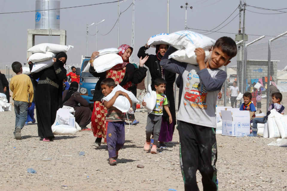 People receive aid at a camp in Daquq