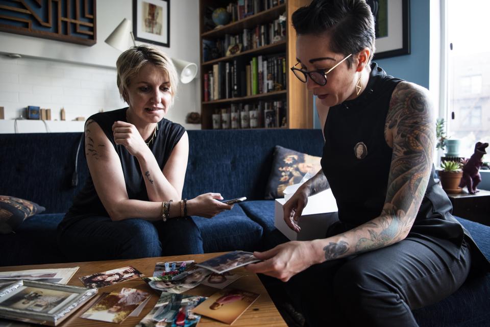 Jess McIntosh, left, and Ali Cole look over family pictures in Cole's Brooklyn, New York, home. (Photo: Damon Dahlen/HuffPost)