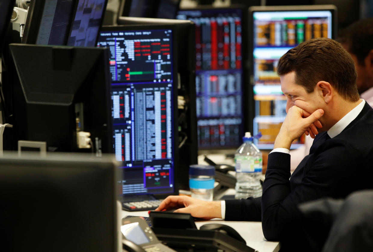 Traders work at their desks whilst screens show market data at CMC Markets in London, Britain, January 16, 2019. REUTERS/John Sibley