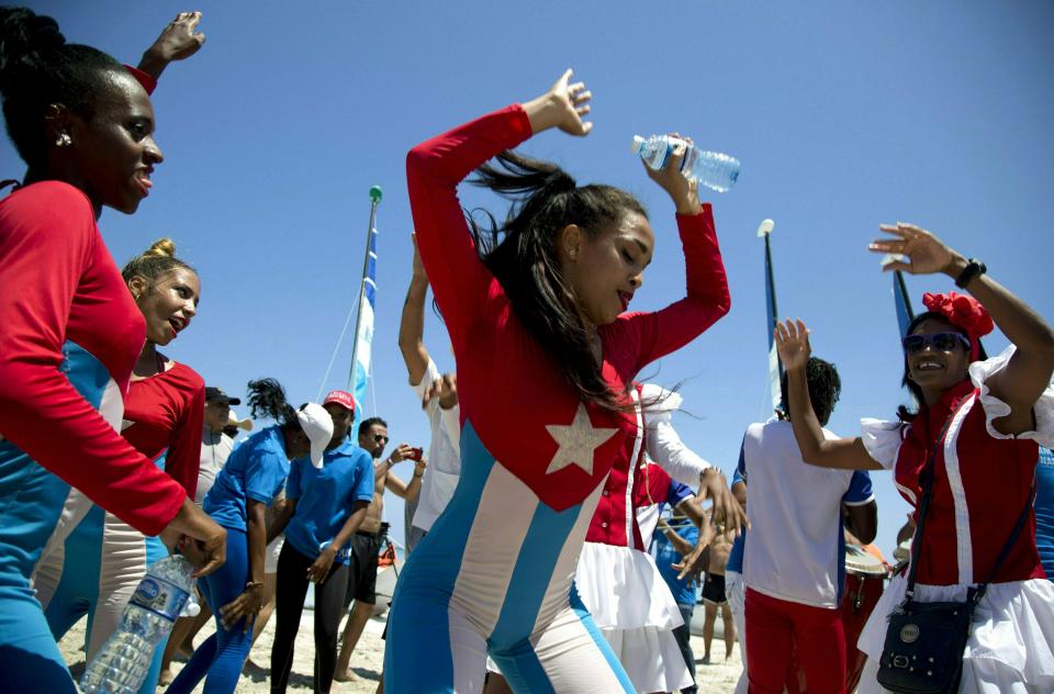 In this May 12, 2019 photo, Hotel Royalton staff entertain tourists during a beach party, in Varadero, Cuba. The island country has now set a goal of drawing 5 million tourists in 2019. (AP Photo/Ismael Francisco)