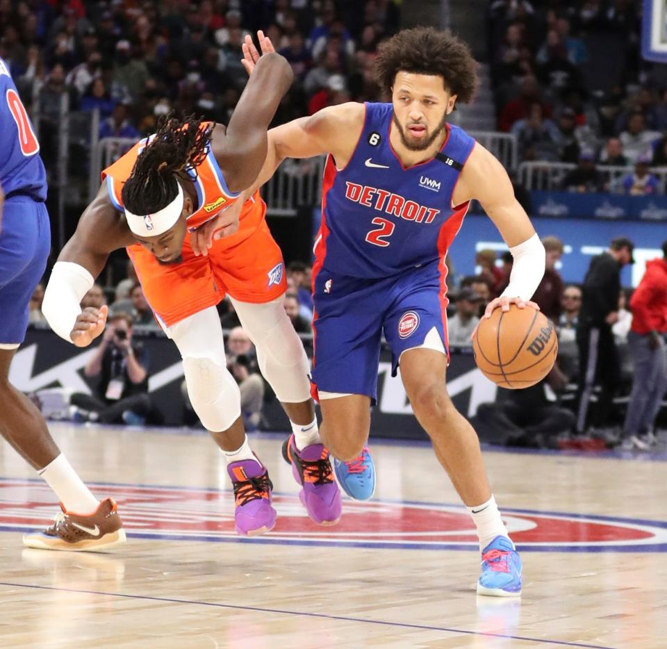 Detroit Pistons guard Cade Cunningham (2) drives Oklahoma City Thunder forward Luguentz Dort (5) during first-quarter action Monday, Nov. 7, 2022, at Little Caesars Arena in Detroit.