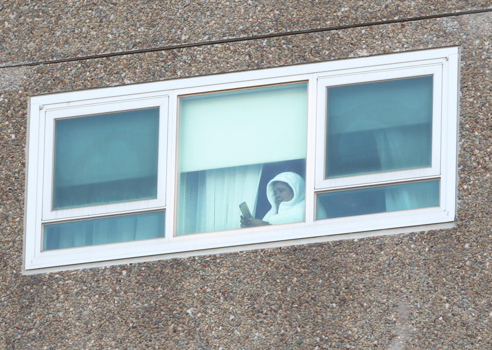 A resident is seen in a window at a Government Commission tower in North Melbourne during the Covid lockdown. 