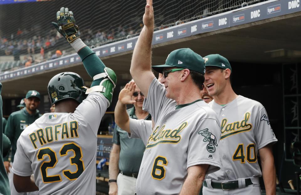 Oakland Athletics' Jurickson Profar is greeted by manager Bob Melvin (6) and starting pitcher Chris Bassitt (40) after hitting a grand slam in the third inning of a baseball game against the Detroit Tigers, Thursday, May 16, 2019, in Detroit. (AP Photo/Carlos Osorio)