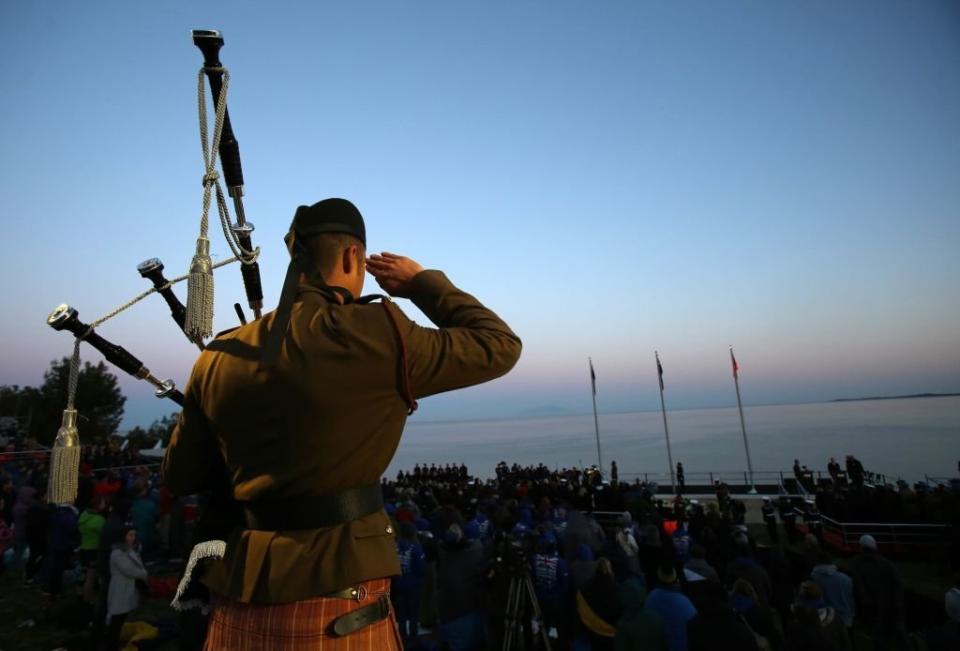 CANAKKALE, TURKEY - APRIL 25 : A soldier salutes to people who wrap themselves with sleeping bag and thermal blankets during the ANZAC Dawn service in Canakkale, Turkey on April 25, 2017. Thousands of Australian and New Zealander people attend the dawn service at Anzac Cove in commemoration of the 102nd anniversary of Canakkale Land Battles on Gallipoli Peninsula.   (Photo by Rasit Aydogan/Anadolu Agency/Getty Images)