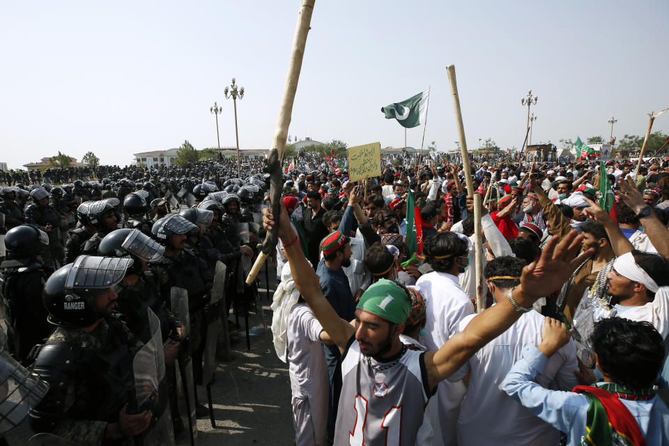 Supporters of ousted Pakistani Prime Minister Imran Khan chant slogans next to para military soldiers stopping them to march towards parliament during in an anti government rally, in Islamabad, Pakistan, Thursday, May 26, 2022. Defiant former Prime Minister Khan early Thursday warned Pakistan's government to set new elections in the next six days or he will again march on the capital along with 3 million people. (AP Photo/Anjum Naveed)