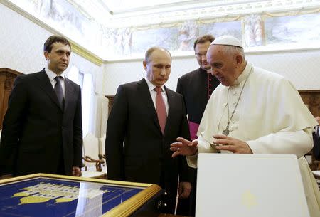 Russian President Vladimir Putin (C) exchange gifts with Pope Francis during a private meeting at Vatican City, June 10, 2015. REUTERS/Gregorio Borgia/Pool