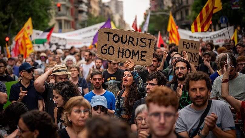 Around 500 Barcelona residents protest against mass tourism during an exhibition of Formula 1 racing cars held in the Spanish city on June 19, 2024. 