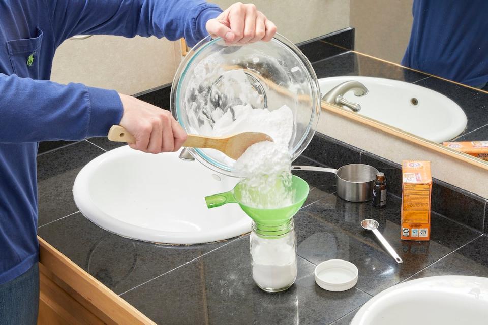 Woman storing DIY toilet bowl cleaner in a glass jar.