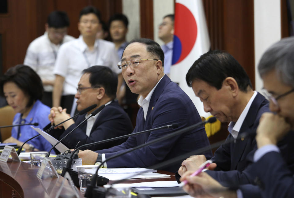 South Korean Economy and Finance Minister Hong Nam-ki, center, speaks as he presides over a meeting to discuss ways to respond to Japan's latest trade restrictions against South Korea at the government complex in Seoul, South Korea, Monday, Aug. 5, 2019. South Korea says it will spend 7.8 trillion won ($6.5 billion) over the next seven years to develop technologies for industrial materials and parts as it moves to reduce its dependence on Japan during an escalating trade row. (AP Photo/Ahn Young-joon)