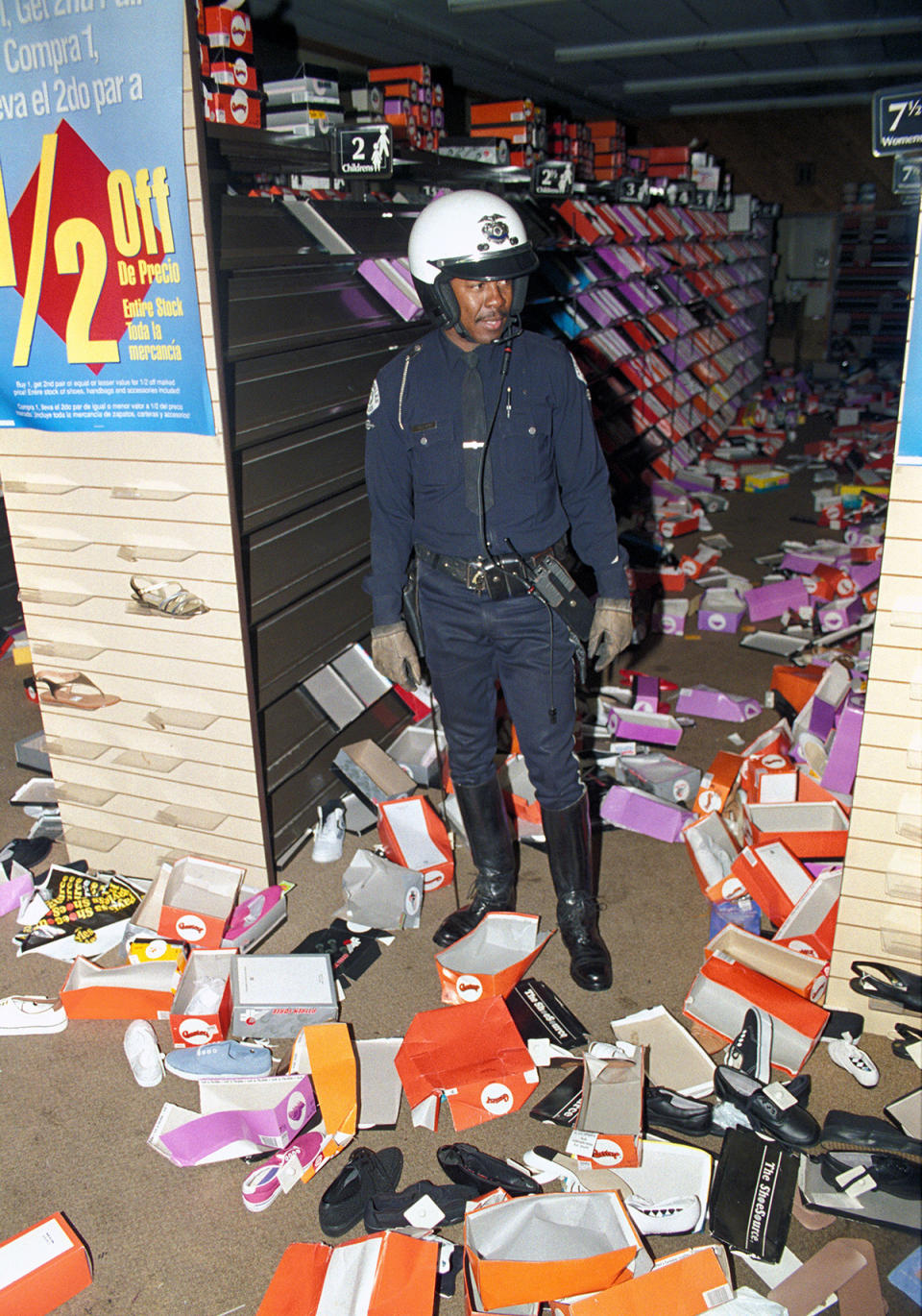 Police officer stands in aisle of looted store