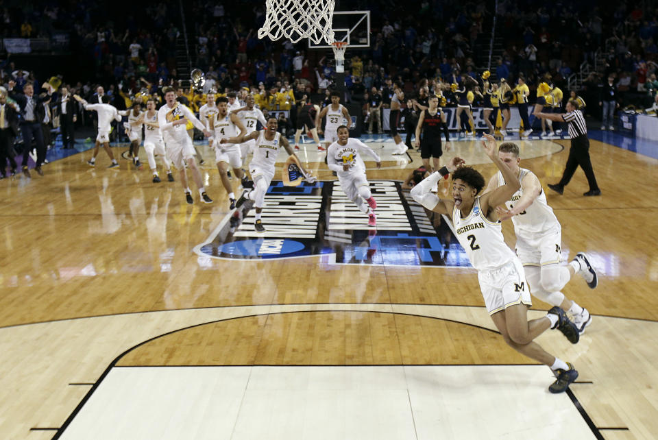 FILE - Michigan guard Jordan Poole (2) is chased by teammates after making a 3-point basket at the buzzer to win an NCAA men's college basketball tournament second-round game against Houston Saturday, March 17, 2018, in Wichita, Kan. Michigan won 64-63. (AP Photo/Charlie Riedel)