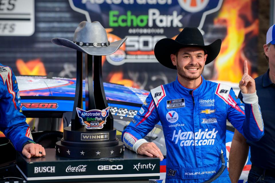 Kyle Larson celebrates with the trophy after winning the 2021 NASCAR Cup Series playoff race at Texas Motor Speedway.