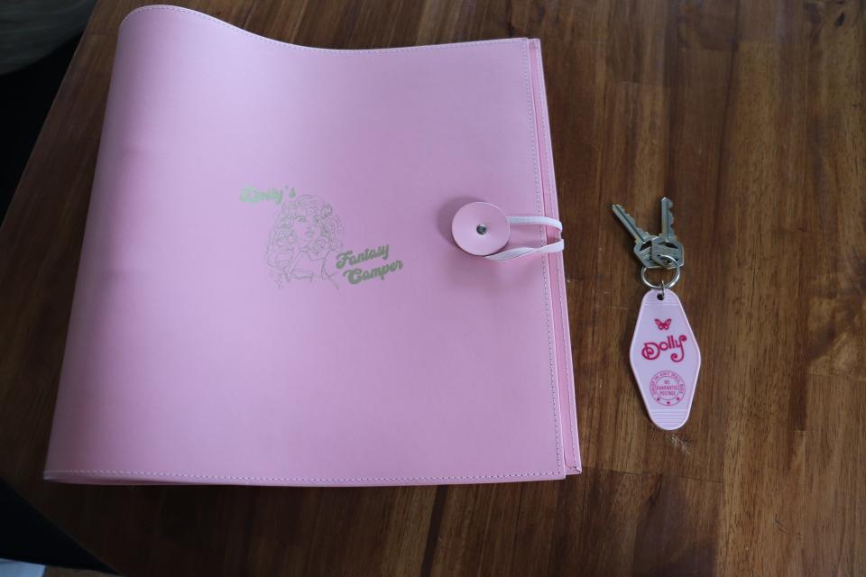 A pink guestbook and key for a Dolly Parton-themed RV