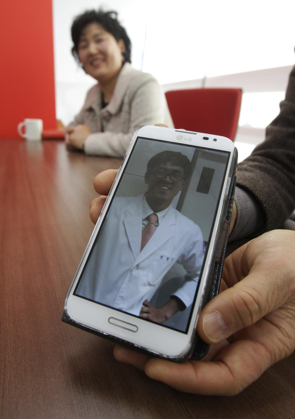 In this Friday, Jan. 9. 2014 photo, a photo of 26-year-old dentist Jeon Seong-Jin is shown by his father Jeon Jang-Beom and mother Yoon Hyun-Jin during an interview in Seoul, South Korea. Jeon Seong-Jin is being punished for a crime that is not a crime at all in most of the world. A Jehovah’s Witness, he has refused to become a soldier in South Korea, where all able-bodied male citizens are required to serve about 21 months in the army. More than 660 conscientious objectors were jailed each year in South Korea from 2004 to 2012, far more than any other country. Eritrea comes in second with only about 50 imprisoned, according to the official website of Jehovah’s Witnesses, who often refuse military service because they believe the Bible forbids warfare. (AP Photo/Ahn Young-joon)