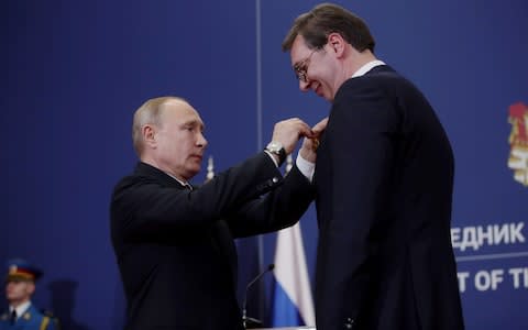 Vladimir Putin awards the Order of Alexander Nevsky to Serbian president Aleksander Vucic in Belgrade last month - Credit: Oliver Bunic/Bloomberg