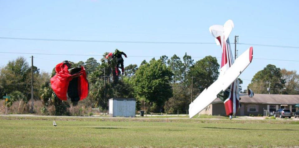 This photo released by the Polk County Sheriff's Office shows a plane nose-diving into the ground after getting tangled with a parachutist, left, Saturday March 8, 2014, at the South Lakeland Airport in Mulberry, Fla. Both the pilot and jumper hospitalized with minor injuries. (AP Photo/Polk County Sheriff's Office, Tim Telford) MANDATORY CREDIT