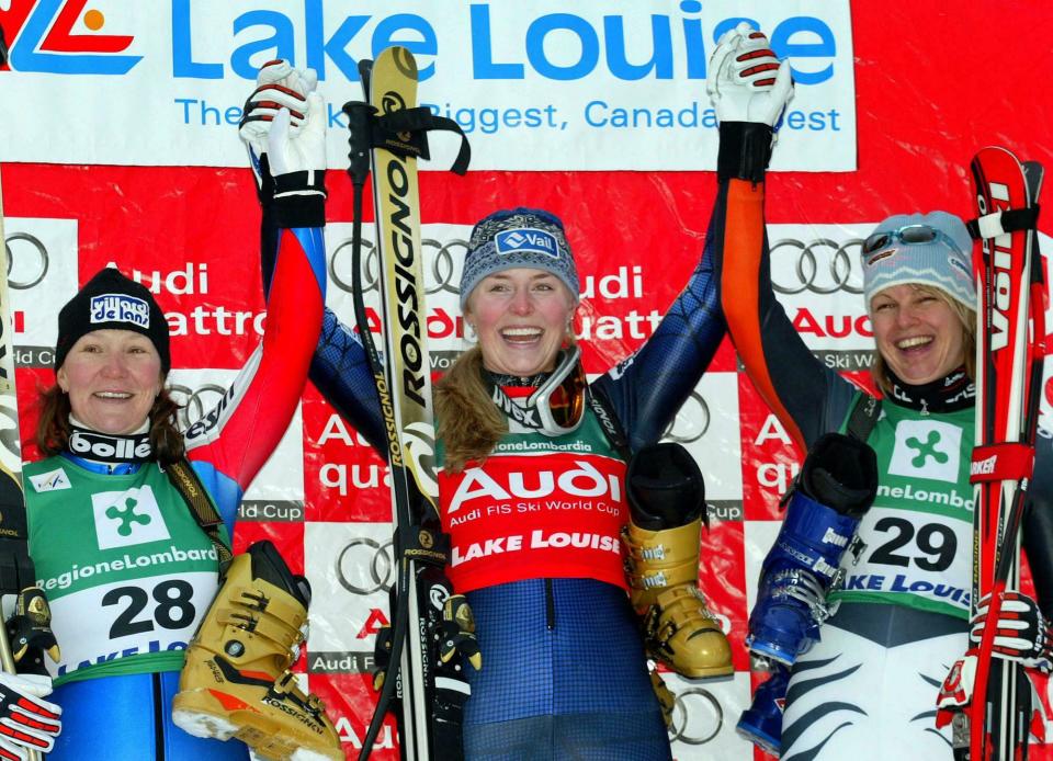 FILE - In this Friday, Dec. 3, 2004 file photo Lindsey Vonn, then going by her maiden name of Lindsey Kildow, center, of the United States, celebrates her first win in a women's World Cup downhill in Lake Louise, Alberta, Canada. Carole Montillet-Charles, left, of France came second and Hilde Gerg, of Germany, placed third. (AP Photo/Jeff McIntosh, File)