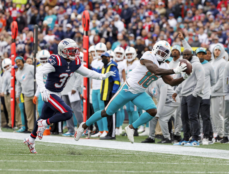 Miami Dolphins wide receiver Tyreek Hill (10) catches a pass against New England Patriots cornerback Jonathan Jones (31) during first quarter of an NFL football game, in Foxborough, Mass., Sunday, Jan. 1, 2023. (David Santiago/Miami Herald via AP)