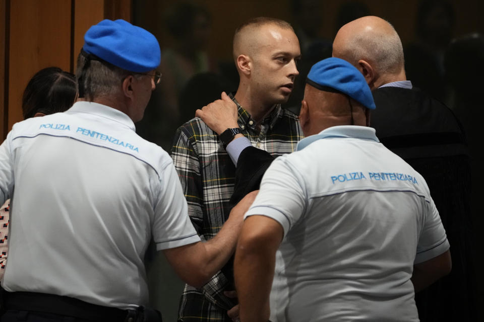 Finnegan Lee Elder, center, is hugged by his lawyer Renato Borzone, after the reading of the judgment at the end of a hearing for the appeals trial in which he is facing murder charges for killing Italian Carabinieri paramilitary police officer Mario Cerciello Rega, in Rome, Wednesday, July 3, 2024. (AP Photo/Alessandra Tarantino)