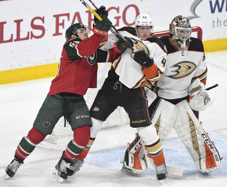 Anaheim Ducks' Cam Fowler, center, pushes Minnesota Wild's Zack Mitchell, left, away from Ducks' goal John Gibson, right in the first period of an NHL hockey game, Tuesday, Feb. 14, 2017, in St. Paul, Minn.(AP Photo/Tom Olmscheid)