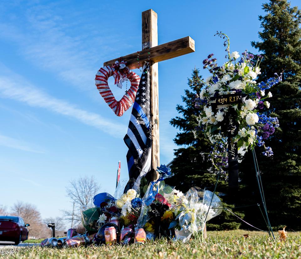 A growing memorial for Milwaukee Police Officer James J. Nowak is seen at the intersection of South Pennsylvania Avenue and Oak Street in Oak Creek, Wis.