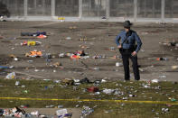 A law enforcement officer looks around the scene following a shooting at the Kansas City Chiefs NFL football Super Bowl celebration in Kansas City, Mo., Wednesday, Feb. 14, 2024. Multiple people were injured, a fire official said.(AP Photo/Charlie Riedel)