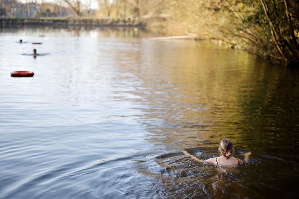 A swimmer paddles in the water at the Hampstead Heath ponds in London. (Getty Images)
