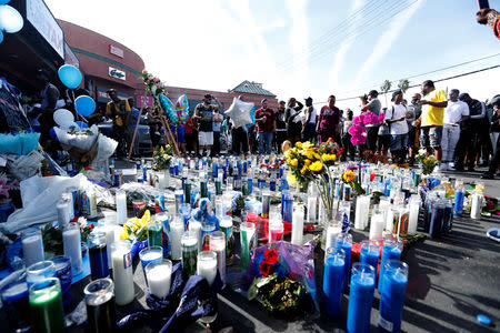 People gather around a makeshift memorial for Grammy-nominated rapper Nipsey Hussle who was shot and killed outside his clothing store in Los Angeles, California, U.S., April 1, 2019. REUTERS/Mario Anzuoni