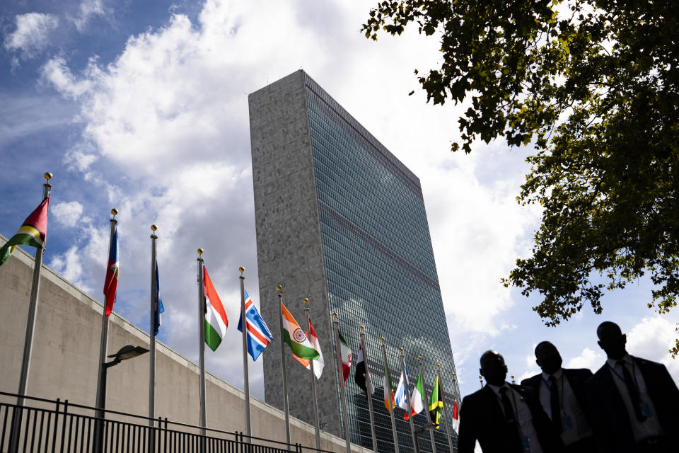 Members of a delegation's entourage wait outside a security checkpoint on the sidewalk in front of the United Nations headquarters, Tuesday, Sept. 21, 2021, during the 76th Session of the U.N. General Assembly in New York. (AP Photo/John Minchillo, Pool)