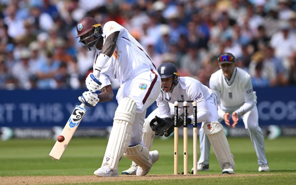 England fielder Joe Root and wicketkeeper Jamie Smith look on as Jason Holder hits out during day one of the 3rd Test Match between England and West Indies at Edgbaston on July 26, 2024 in Birmingham, England