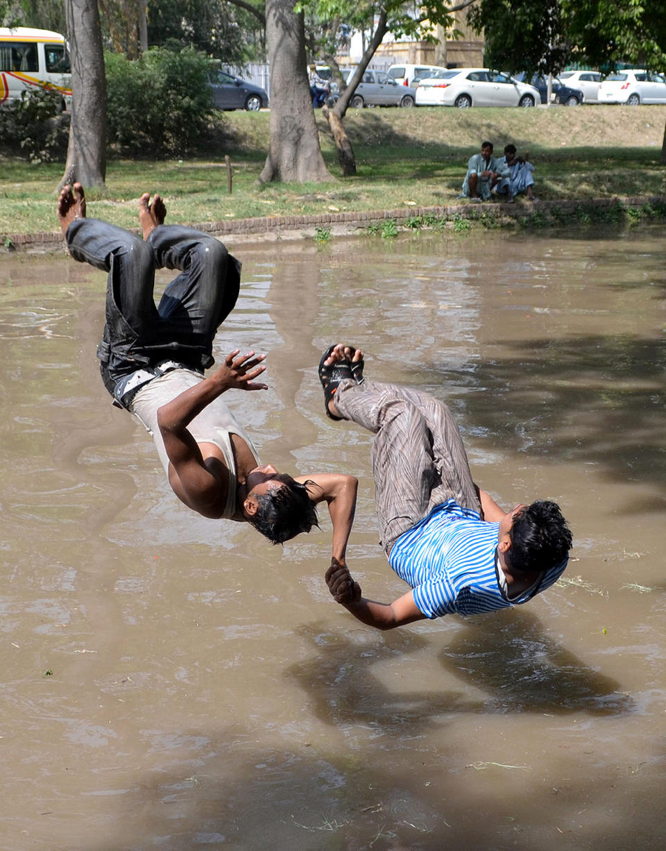 <p>Locals are seen mid-jump as they attempt to cool off in a canal during a heat wave in Lahore, Pakistan. </p>