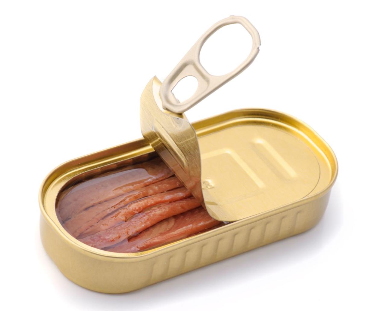 anchovies preserved in oil in metal can, with the can opened