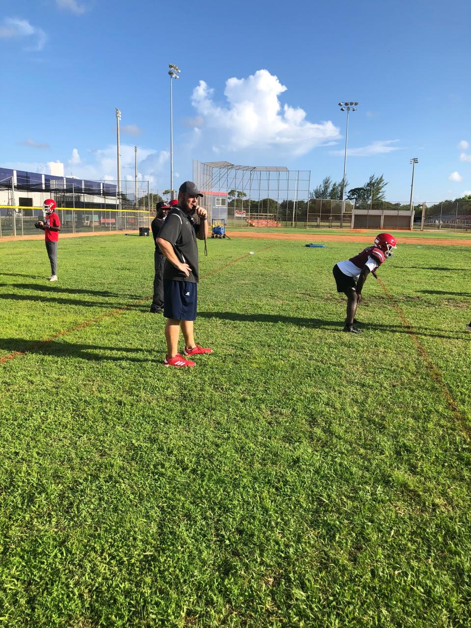 First-year Forest Hill head coach Garrett Necaise (left) watches drills prior to the Falcons' 2022 season.