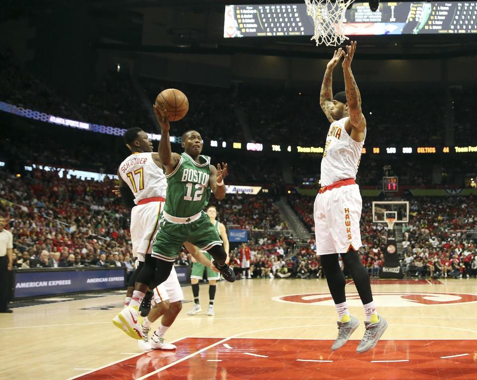 Boston Celtics guard Terry Rozier (12) goes up for as shot against Atlanta Hawks guard and Dennis Schroder (17) and forward Mike Scott (32) in the second half of an NBA playoff basketball game Tuesday, April 19, 2016, in Atlanta . Atlanta won 89-72 and leads the series 2-0. (AP Photo/John Bazemore)