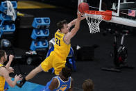 FILE - In this March 30, 2021, file photo, Michigan guard Franz Wagner (21) drives to the basket over UCLA forward Kenneth Nwuba (14) during the first half of an Elite 8 game in the NCAA men's college basketball tournament in Indianapolis. (AP Photo/Michael Conroy, File)