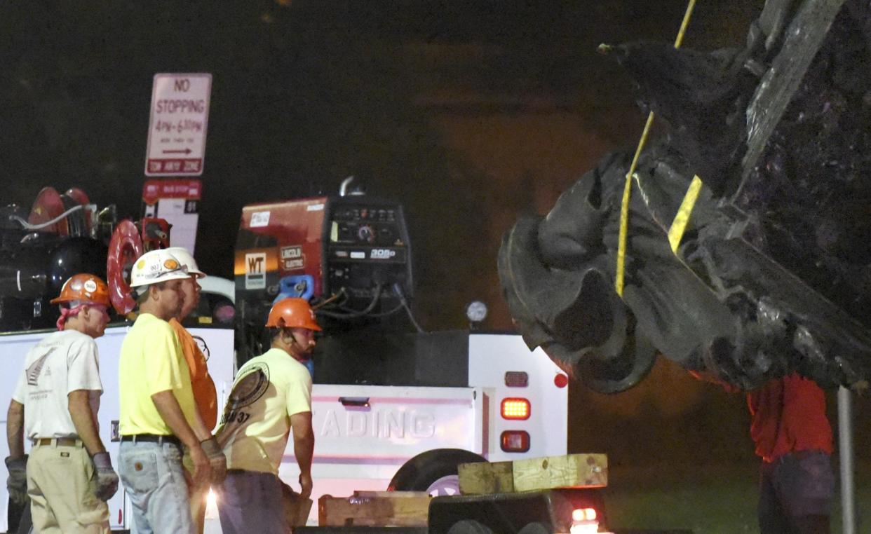 Workers in Baltimore are pictured removing a Confederate monument there: AP