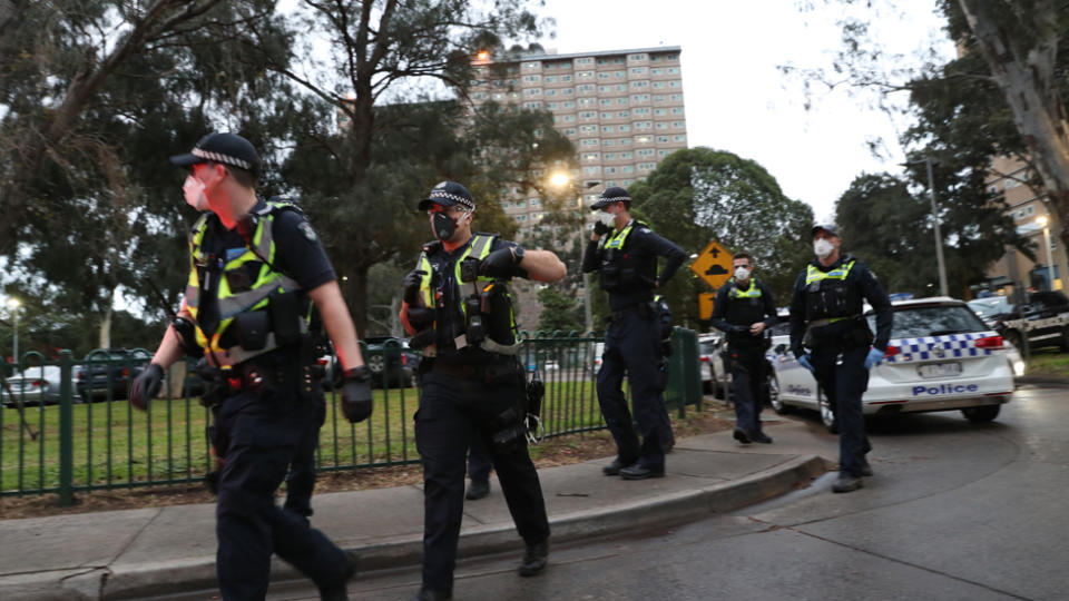 Source: Police are seen enforcing a lockdown at public housing towers on Racecourse Road in Flemington, Melbourne. Source: AAP