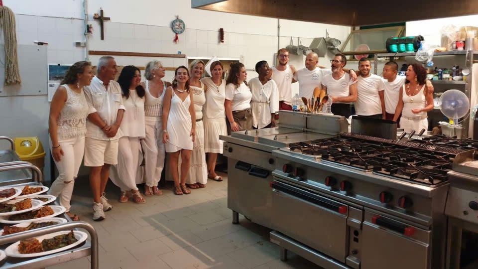 Guests pose for a photo with the male convicts who staff the hotel on Pianosa. - Courtesy Giulia Manca