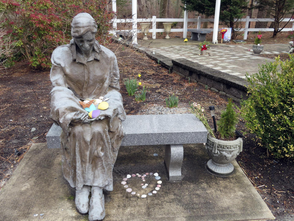 A sculpture of a grieving mother sits at a memorial garden, Feb. 21, 2023, in Toms River, N.J. for children who died from any cause. Many residents of Toms River, where the former Ciba-Geigy chemical plant dumped toxic waste into the Toms River and directly onto the ground, oppose a settlement with the site's current owner, BASF Corp. to restore natural resources at the site as inadequate and ill-advised. (AP Photo/Wayne Parry)