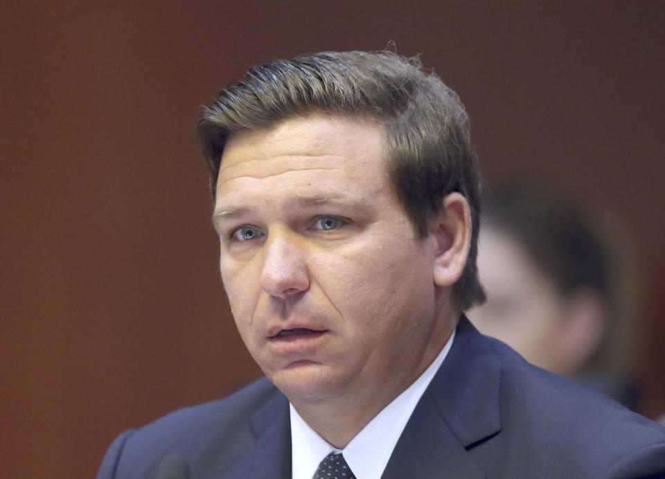 FILE - In a June 4, 2019 file photo, Florida Gov. Ron DeSantis listens to the proceedings during a Florida cabinet meeting, in Tallahassee, Fla. Floridians could eventually gain access to cheaper prescription drugs from Canada and other foreign countries under legislation signed into law Tuesday, June 11, 2019 by Gov. Ron DeSantis, if the federal government gives it a green light.(AP Photo/Steve Cannon, File)