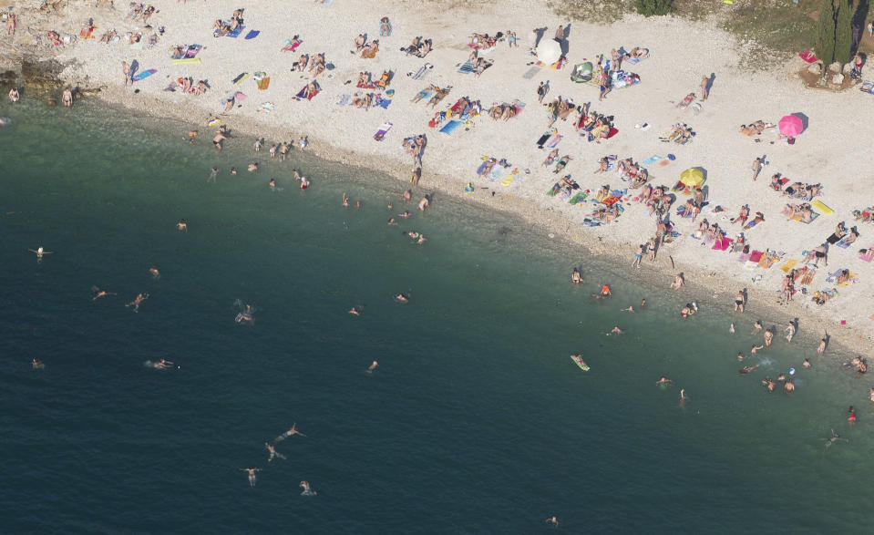In this aerial photo taken June 17, 2013, tourists enjoy the beach in Pula, northern Adriatic. On Monday July 1, 2013, Croatia will become the 28th EU member, the bloc's first addition since Bulgaria and Romania joined in 2007. Croatia's membership marks a historic turning point for the small country, which went through carnage after declaring independence from the former Yugoslavia in 1991. (AP Photo/Darko Bandic)