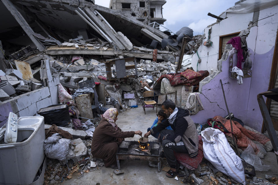 Members of the Al-Rabaya family break their fast during the Muslim holy month of Ramadan outside their destroyed home by the Israeli airstrikes in Rafah, Gaza Strip, Monday, March 18, 2024. (AP Photo/Fatima Shbair)