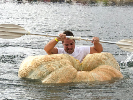 A man paddles his giant pumpkin boat during the raditional pumpkin race in Lohmar, Germany October 3, 2018. Reuters/David Sahl