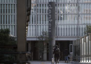 Men walk near the headquarters of Japanese advertising company Dentsu Inc. in Tokyo Wednesday, Jan. 23, 2019. One of Japan's most powerful companies, the giant agency Dentsu Inc. is part of an investigation into alleged vote-buying connected with landing the 2020 Olympics for Tokyo. (AP Photo/Eugene Hoshiko)